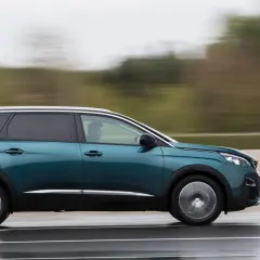 Turkusowy Peugeot 5008 2.0 HDI w ruchu, z rozmytym tłem.