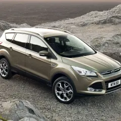 Złoty Ford Kuga na kamienistym podłożu. Poznaj jego wymiary i możliwości terenowe.