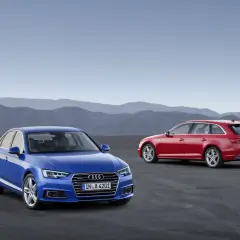 Dwa Audi A4: niebieski sedan i czerwony kombi, stoją na pustkowiu.