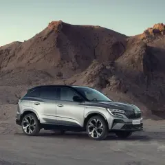 Srebrny Renault Austral na tle pustynnego krajobrazu z górami.