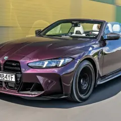 Fioletowy kabriolet BMW M4 z pakietem M na drodze.