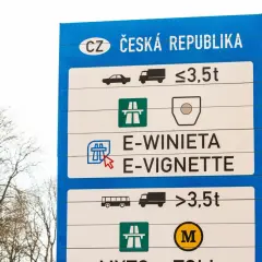 Niebieski znak drogowy z napisem "CZ ČESKÁ REPUBLIKA" i symbolami pojazdów oraz wag.