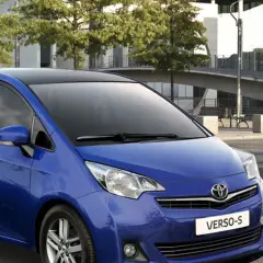 Niebieski minivan Toyota Yaris Verso z czarnym dachem, zaparkowany na zewnątrz.