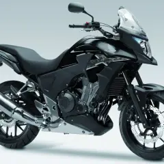 Czarny motocykl Honda CB500X z przyciemnianą szybą i chromowanym wydechem, gotowy na przygodę.