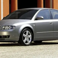 Srebrne Audi A4 B6 1.9 TDI 130KM na tle pomarańczowej ściany.