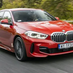 Czerwone BMW Serii 1 F40 w ruchu drogowym, widok z przodu.