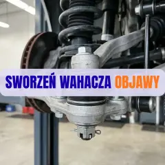 Widok na element zawieszenia samochodu. Widoczny sworzeń wahacza, sprężyna i tarcza hamulcowa. Napis "SWORZEŃ WAHACZA OBJAWY".