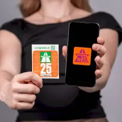 Kobieta trzyma winietę szwajcarską i smartfon z aplikacją e-winiety.