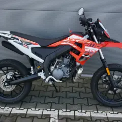 Pomarańczowy motocykl **senda** z białymi i czarnymi akcentami, gotowy do jazdy po mieście.