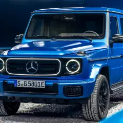 Niebieski Mercedes-Benz Klasy G z nowoczesnymi światłami LED na tle niebieskiego tła.