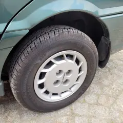 Srebrna felga z logo Daewoo na zielonym samochodzie.
