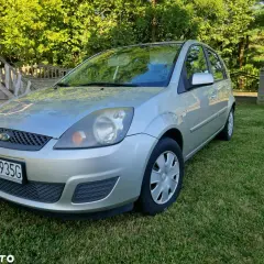 Srebrny Ford Fiesta Mk5 na trawniku, z widocznym numerem rejestracyjnym PTU 4935G.