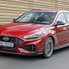 Czerwony Hyundai i30 wagon N Line pędzi po drodze, błyszcząc w słońcu.