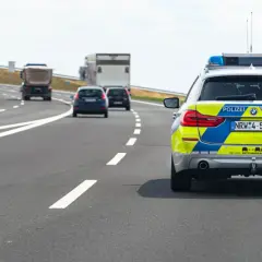 Niemiecki radiowóz na autostradzie, jadący za innymi pojazdami.