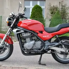 Czerwony Kawasaki ER-5, gotowy do jazdy po miejskich ulicach. Klasyczny wygląd i niezawodność.