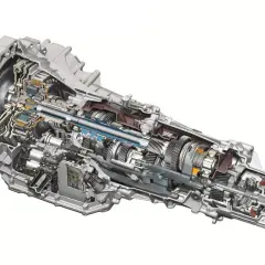 Przekładnia automatyczna w przekroju, ukazująca skomplikowany mechanizm zębatek, wałków i elektronicznych sterowników. S tronic to serce wielu nowoczesnych pojazdów.