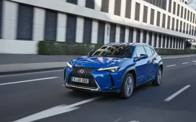 Niebieski Lexus UX 300e w ruchu miejskim. Kompaktowy SUV, którego lexus ux wymiary idealnie sprawdzają się w mieście.