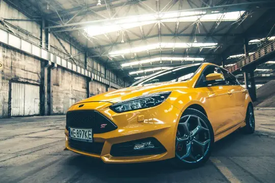 Żółty Ford Focus MK3 1.6 benzyna ST w hangarze, gotowy do jazdy.