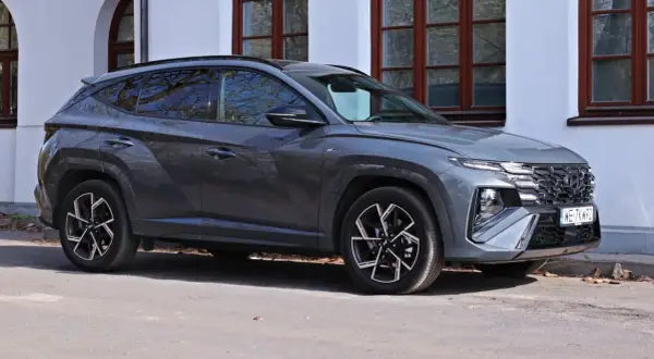 Szary Hyundai Tucson N Line zaparkowany przed budynkiem. Sprawdź aktualną hyundai tucson cena i ofertę.