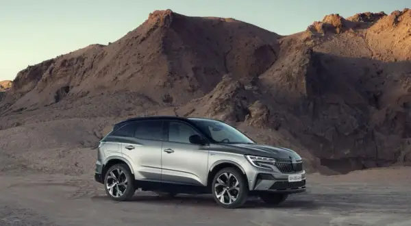 Srebrny Renault Austral na tle pustynnego krajobrazu z górami.