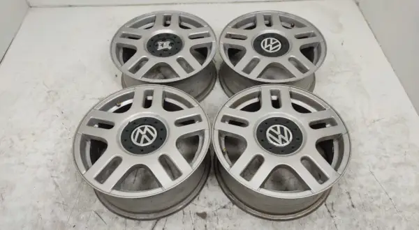 Cztery srebrne felgi aluminiowe Volkswagen z czarnym środkiem i logo VW.