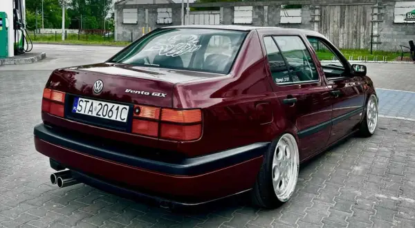 Ciemnoczerwony Volkswagen Vento GLX z felgami BBS stoi na parkingu.
