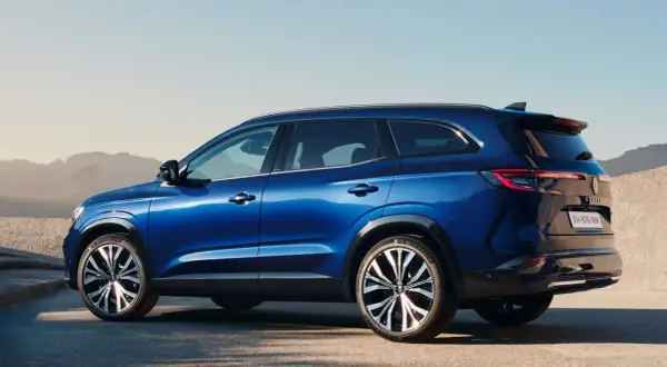 Błękitny Renault Espace 2024 z eleganckimi felgami stoi na tle pustynnego krajobrazu.