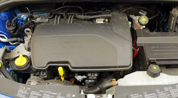 Silnik Renault Clio 3, widok z góry. Widać plastikową osłonę silnika, zbiorniczek płynu chłodniczego i inne elementy.