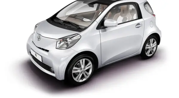 Biały samochód Toyota iQ z czarnym dachem i jasnym wnętrzem, widok z przodu i z boku.