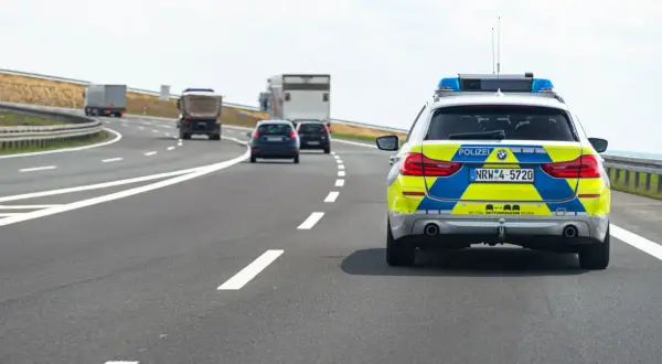 Niemiecki radiowóz na autostradzie, jadący za innymi pojazdami.
