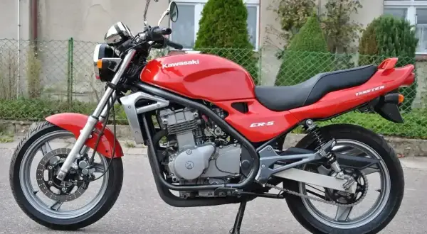 Czerwony Kawasaki ER-5, gotowy do jazdy po miejskich ulicach. Klasyczny wygląd i niezawodność.
