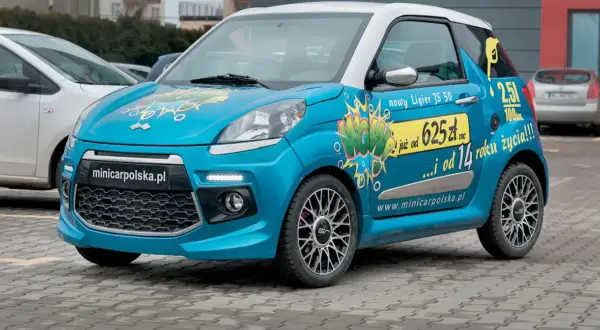 Niebieski czterokołowiec lekki Ligier JS 50 z napisem "WOW" i informacją o cenie.