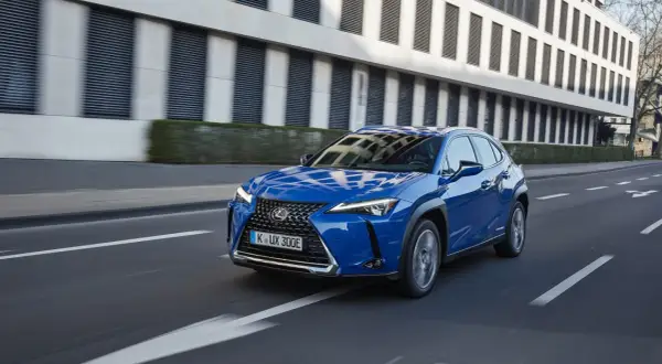 Niebieski Lexus UX 300e w ruchu miejskim. Kompaktowy SUV, którego lexus ux wymiary idealnie sprawdzają się w mieście.