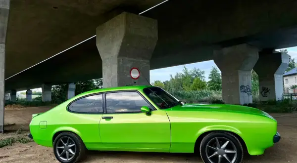 Zielony Ford Capri z lat 70. pod betonowym wiaduktem.