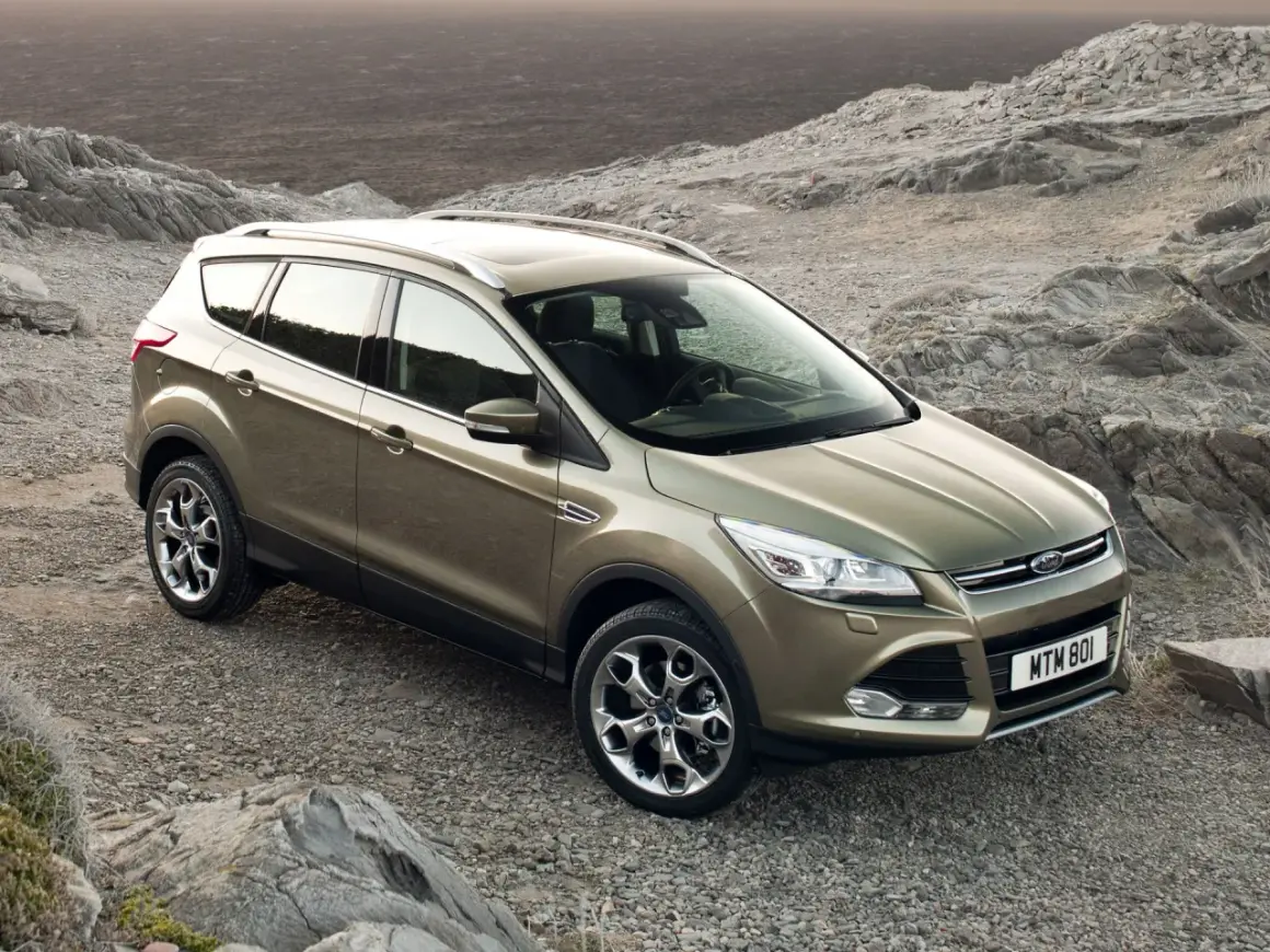 Złoty Ford Kuga na kamienistym podłożu. Poznaj jego wymiary i możliwości terenowe.