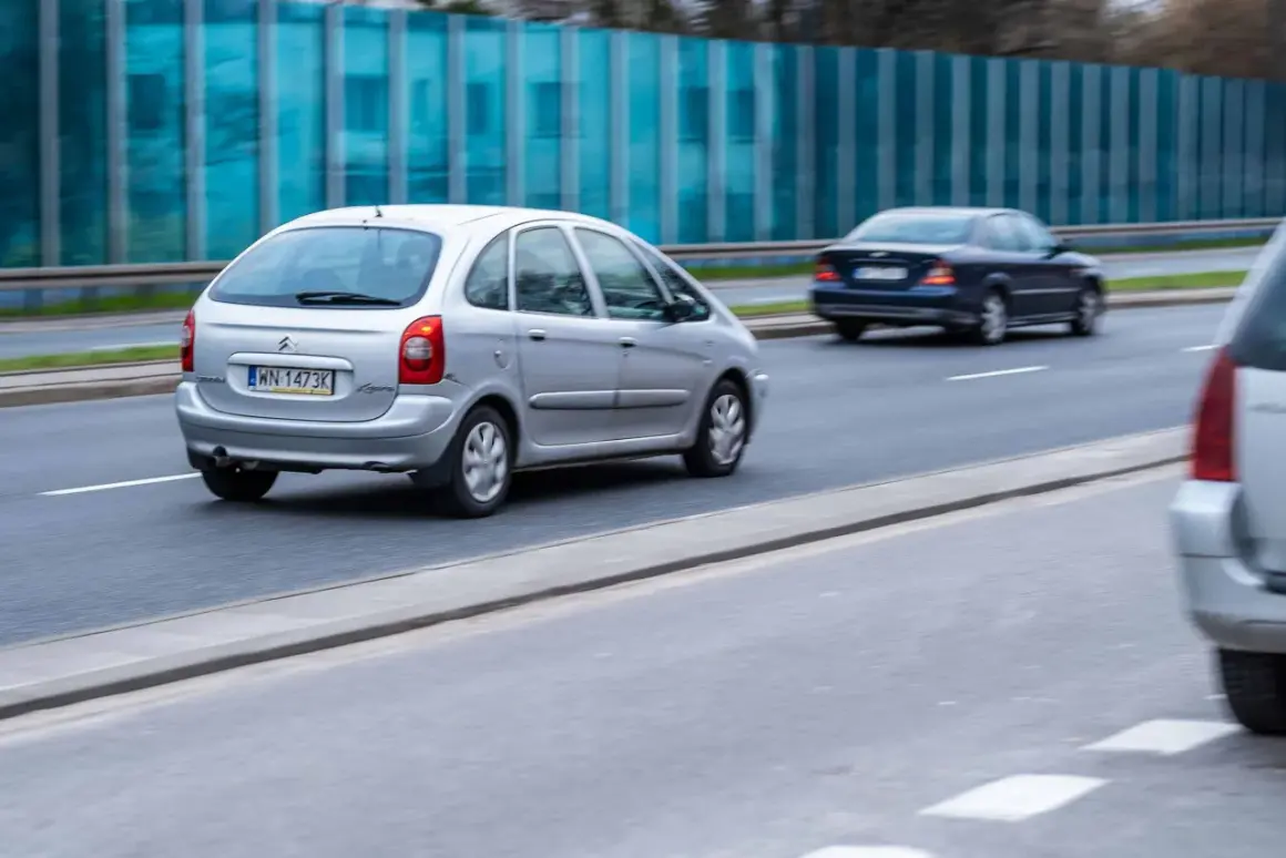 Srebrny Citroën Xsara Picasso jedzie po drodze, obok niebieski sedan.
