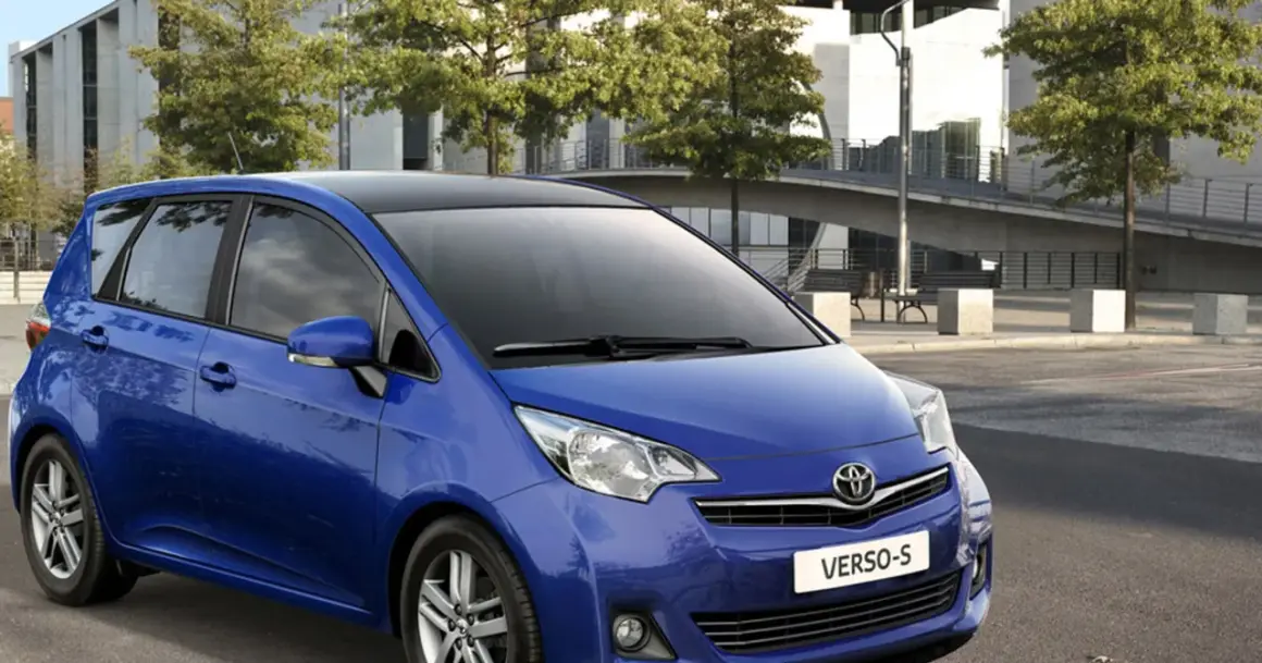 Niebieski minivan Toyota Yaris Verso z czarnym dachem, zaparkowany na zewnątrz.