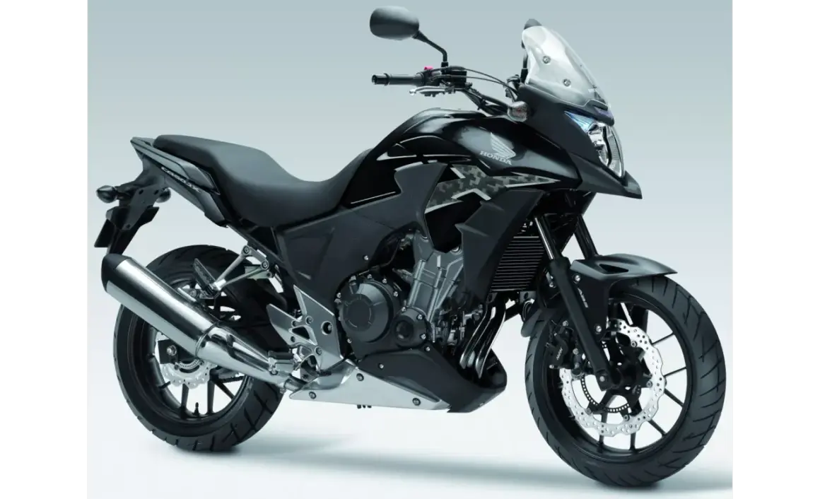 Czarny motocykl Honda CB500X z przyciemnianą szybą i chromowanym wydechem, gotowy na przygodę.