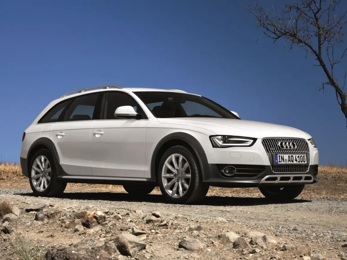Białe Audi A4 B8 Allroad quattro na kamienistej drodze pod błękitnym niebem.