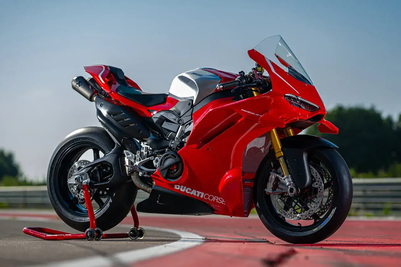 Czerwony motocykl Ducati Panigale V4 na torze wyścigowym, gotowy do jazdy.