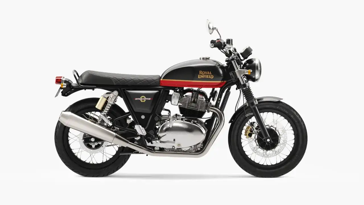 Czarny motocykl Royal Enfield Interceptor 650 z czerwonym i złotym pasem na baku. Klasyczny wygląd, chromowane detale.