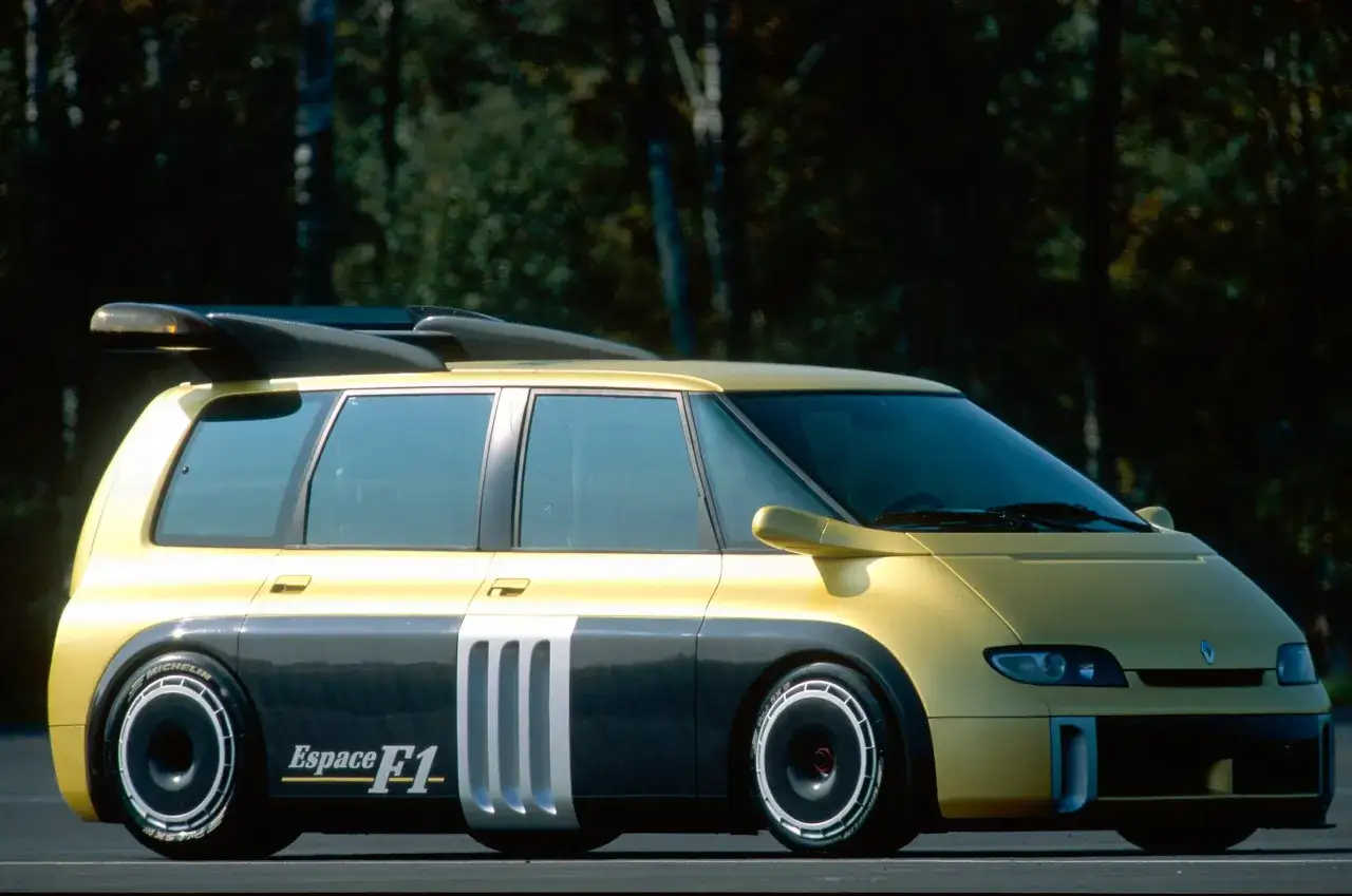 Żółto-szary Renault Espace F1 z masywnym spojlerem i sportowymi felgami, gotowy do wyścigu.