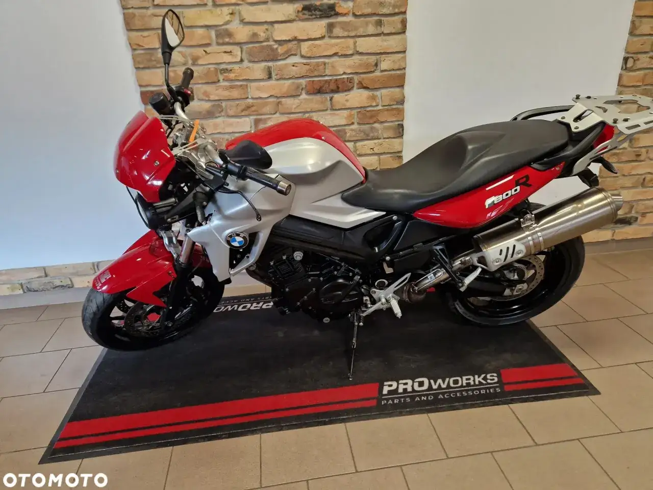 Czerwono-srebrny motocykl BMW F800R z czarnym siedzeniem i bagażnikiem.