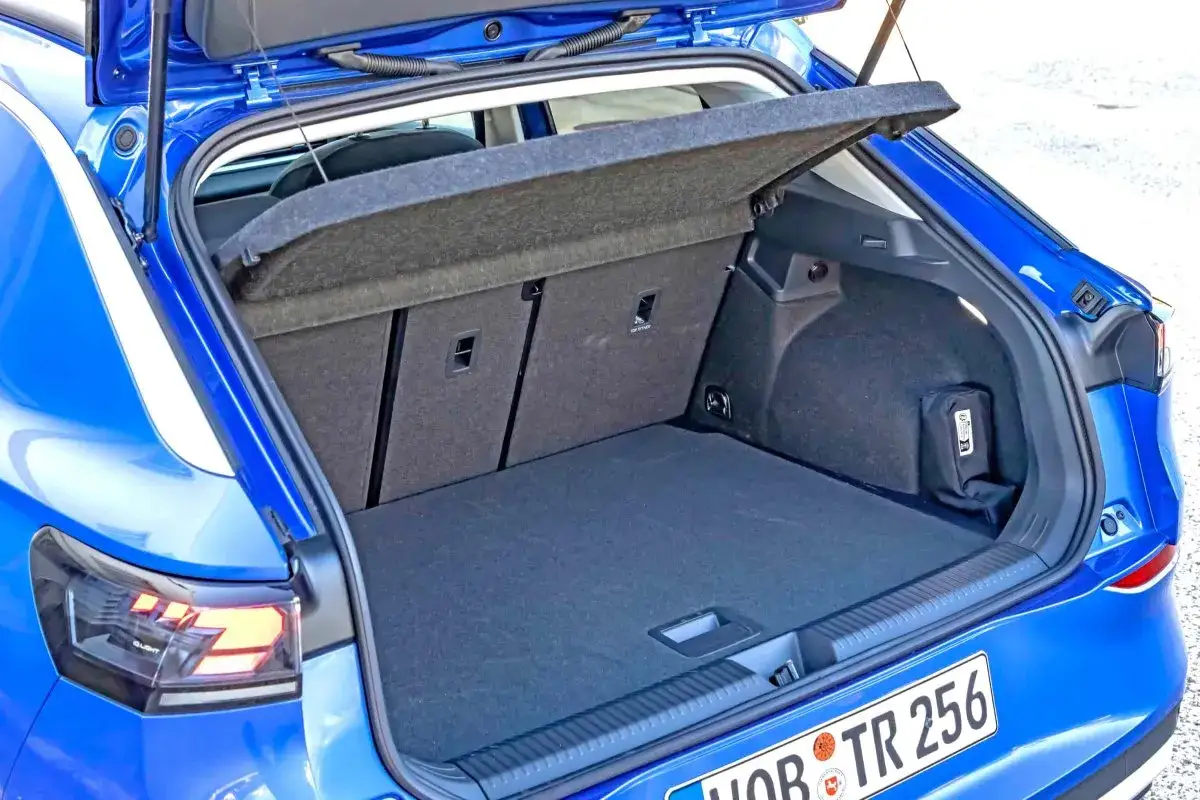 Błękitny Volkswagen T-Roc z otwartym bagażnikiem. Wnętrze jest puste, gotowe na bagaże. Wymiary bagażnika pozwalają na swobodne pakowanie.