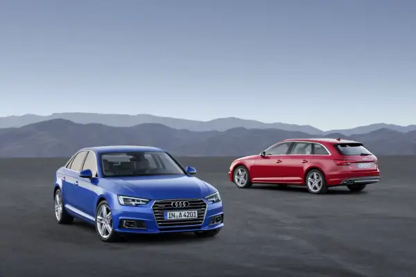 Dwa Audi A4: niebieski sedan i czerwony kombi, stoją na pustkowiu.