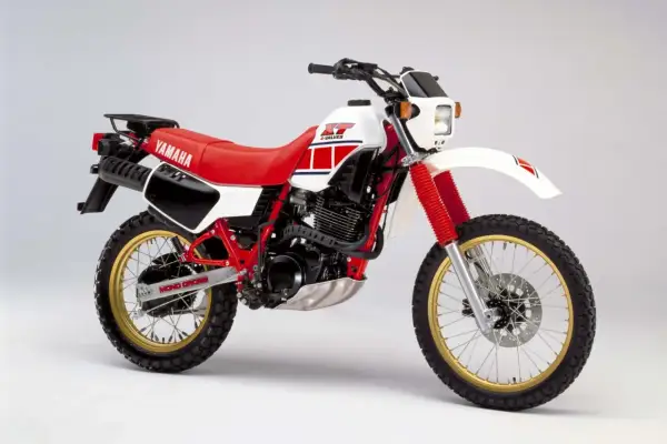Klasyczny motocykl Yamaha XT 600 z czerwonym siedzeniem i białym bakiem, gotowy na przygodę.