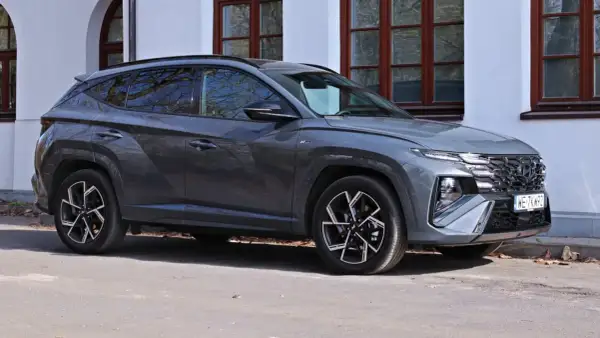 Szary Hyundai Tucson N Line zaparkowany przed budynkiem. Sprawdź aktualną hyundai tucson cena i ofertę.