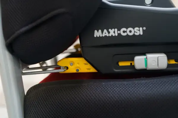 System Isofix co to? Widoczny mechanizm mocowania fotelika samochodowego Maxi-Cosi do siedzenia pojazdu.
