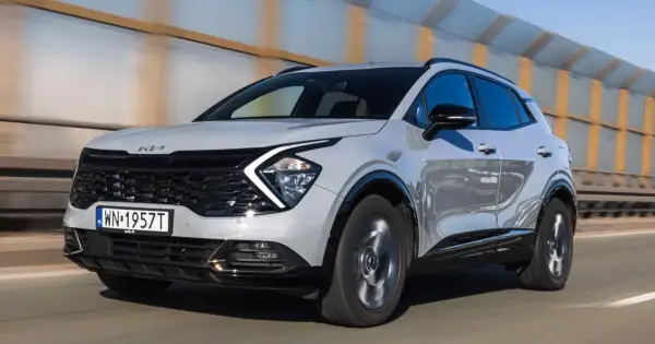 Nowa Kia Sportage w kolorze jasnoszarym pędzi po drodze. Zastanawiasz się, ile kosztuje nowa Kia Sportage?