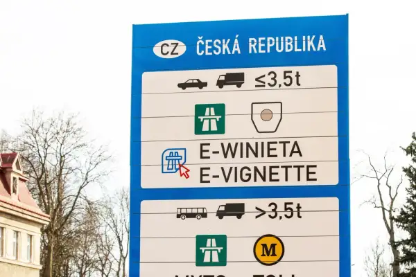 Niebieski znak drogowy z napisem "CZ ČESKÁ REPUBLIKA" i symbolami pojazdów oraz wag.
